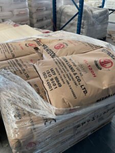 Stacked bulk sacks of imported hot‑melt adhesive raw materials in warehouse