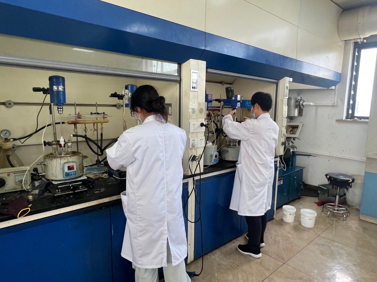 Technicians operate lab reaction equipment